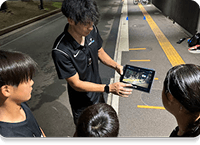 タブレットで動画を見せるコーチ(動画での振り返り)