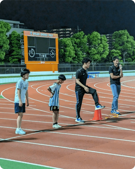 コーチの説明を聞きながらスタート練習をする小中学生